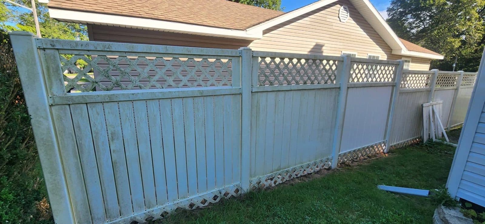White vinyl privacy fence with lattice, green with algae before washing